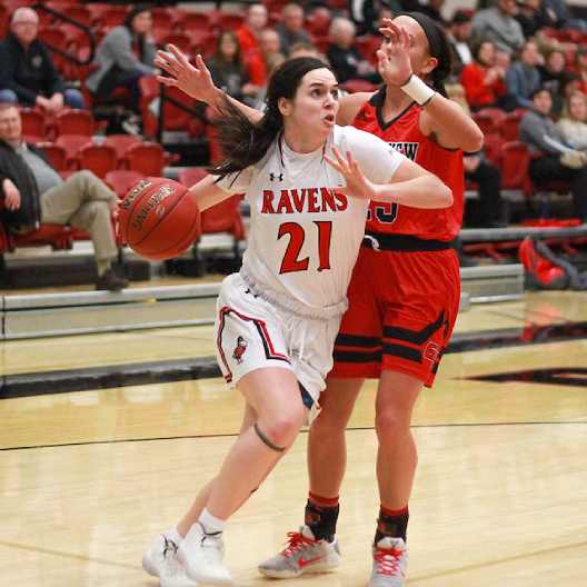 Lady Ravens basketball player pushing past a defender to score