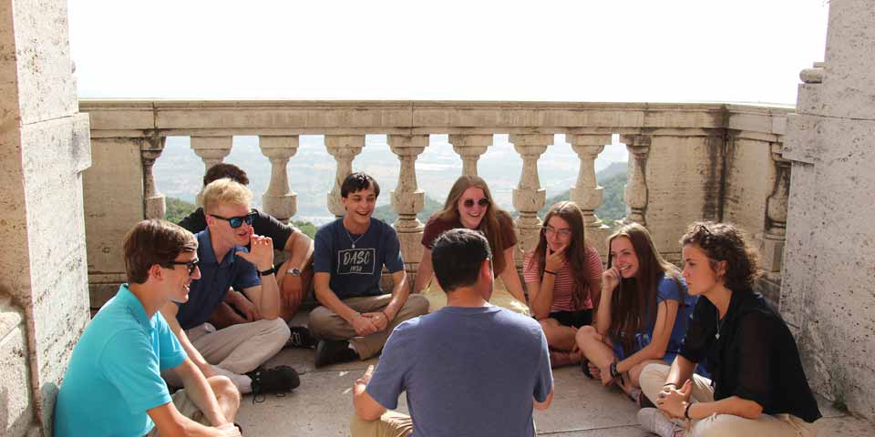 A group of students talking in a circle in Italy.