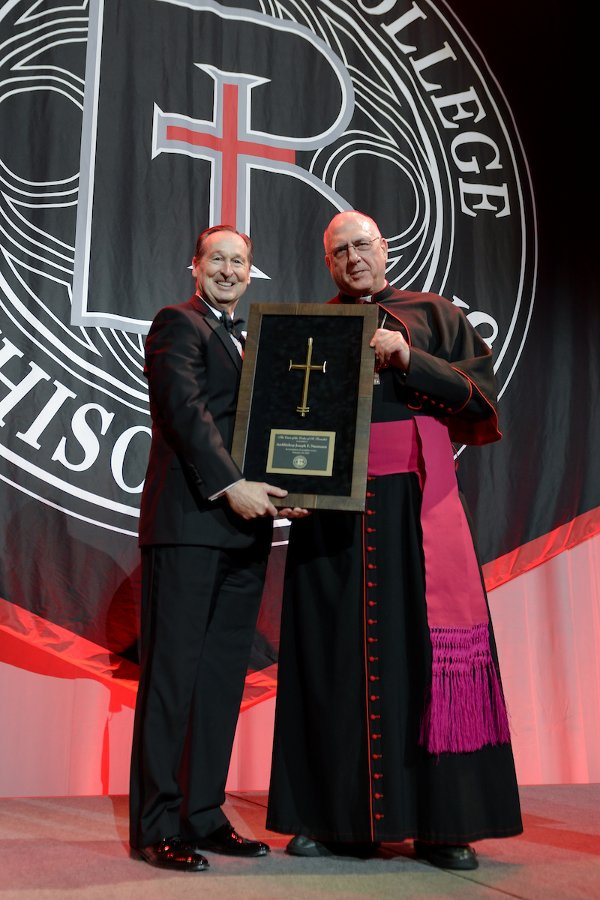President Stephen Minnis presents Archbishop Joseph Naumann with the Cross of the Order of St. Benedict.