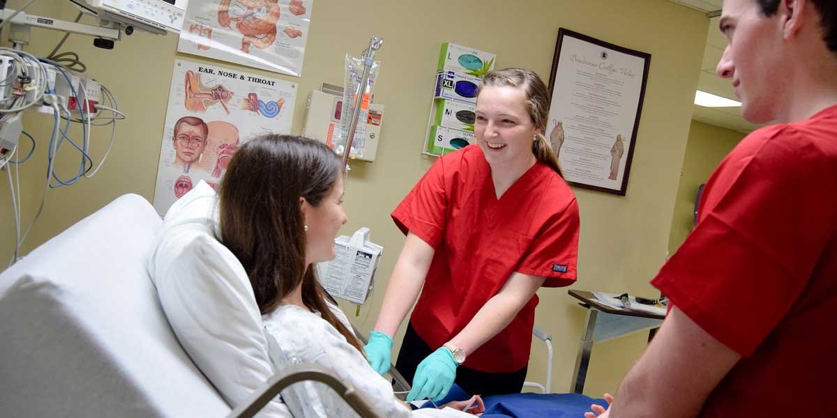 Nursing students practice in a simulation room