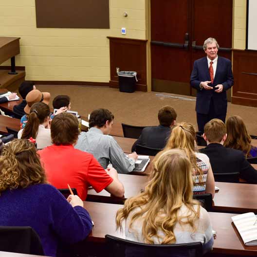 A speaker giving a lecture to a group of students