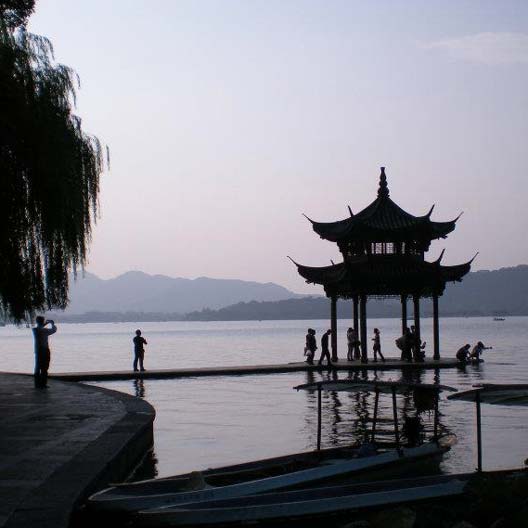 An evening photo of a lake with a gazebo