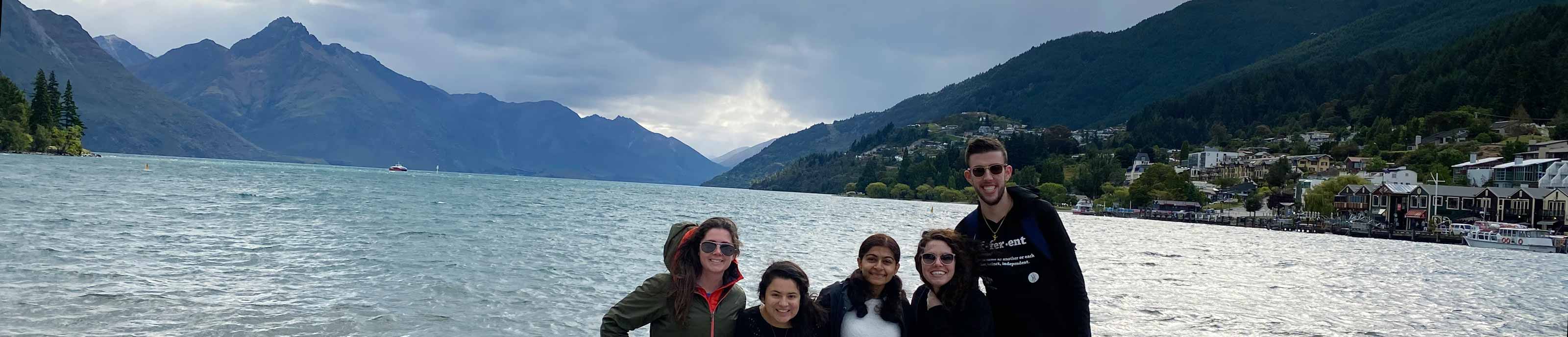 A study abroad group posing for a photo on a beach in New Zealand