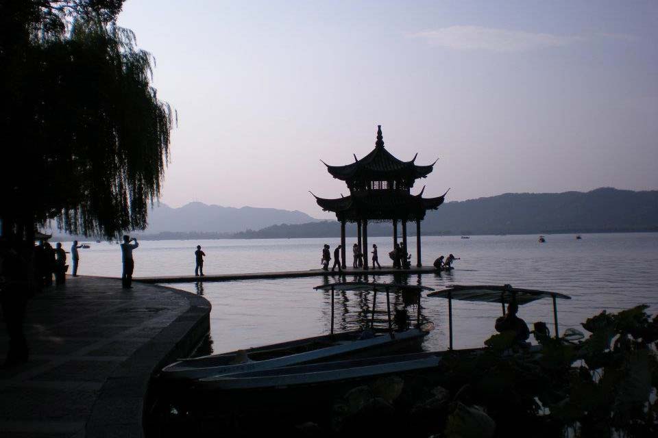 An evening photo of a lake with a gazebo
