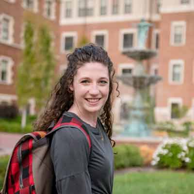 A student poses for a photo on campus