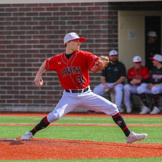 Raven's pitcher winding up to throw a pitch