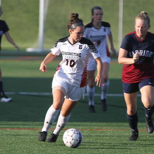 Benedictine College Women's Soccer player pushing the ball down the field