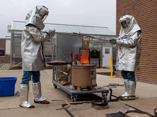 Students work with molten metal