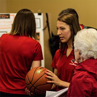 A student holds a basketball during a Discovery Day presentation