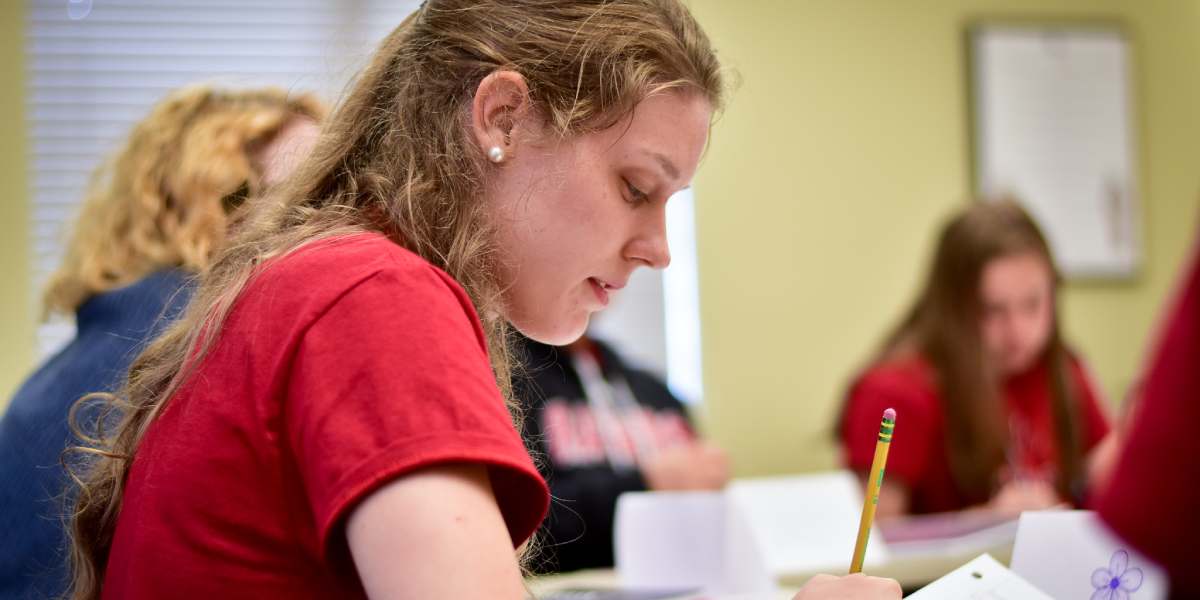 A BCYC Immersion student taking notes in class