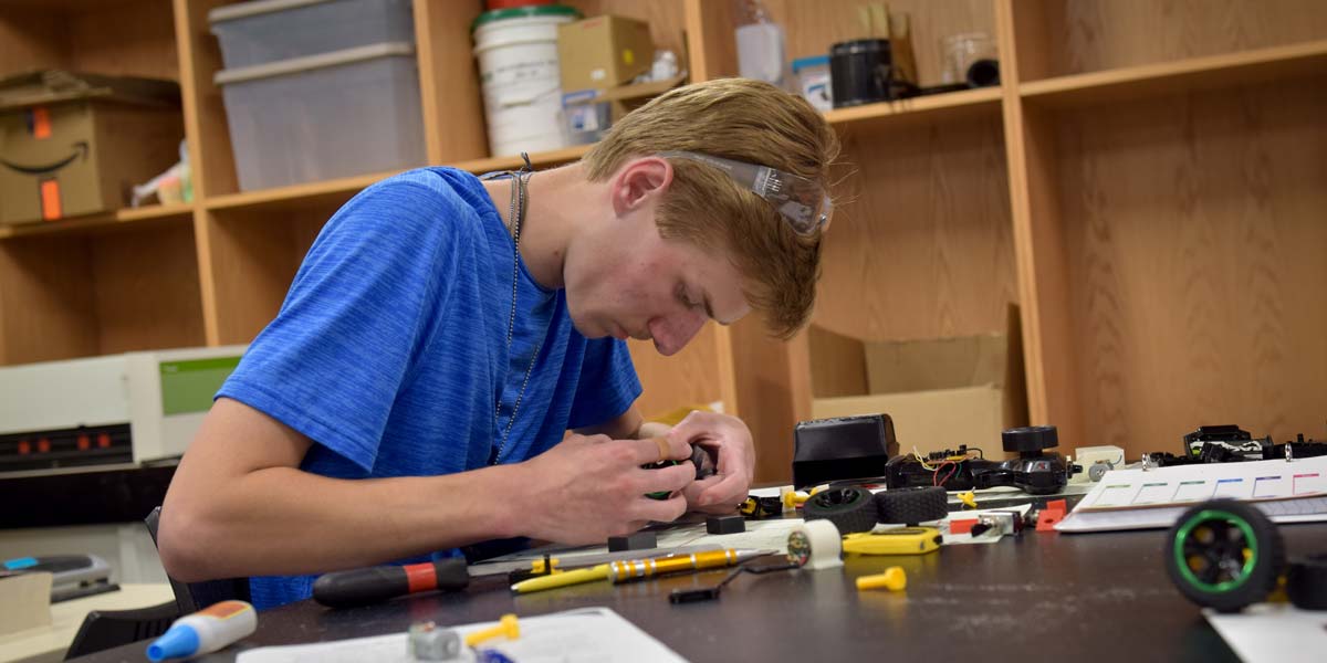 A BCYC Immersion student assembles an engineering project in class