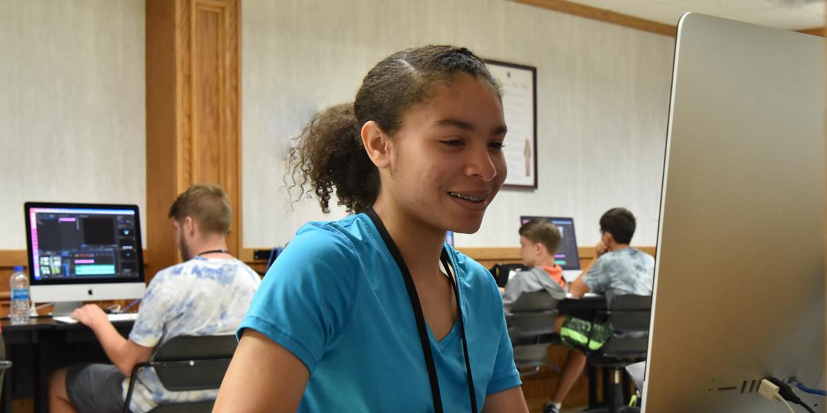 A media specialist works at a computer desk