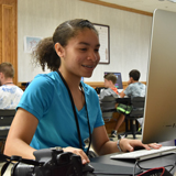 A media specialist works at a computer desk