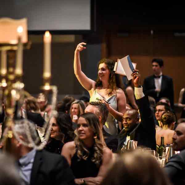 A Scholarship Ball attendee holds up his bid card during Fund-A-Raven