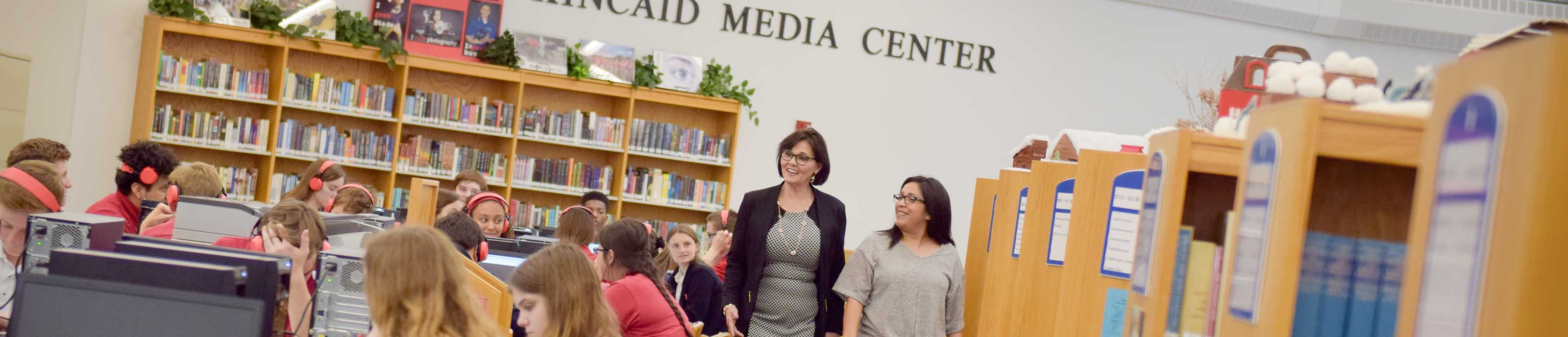 A school principal walks by during a high school class in a media center
