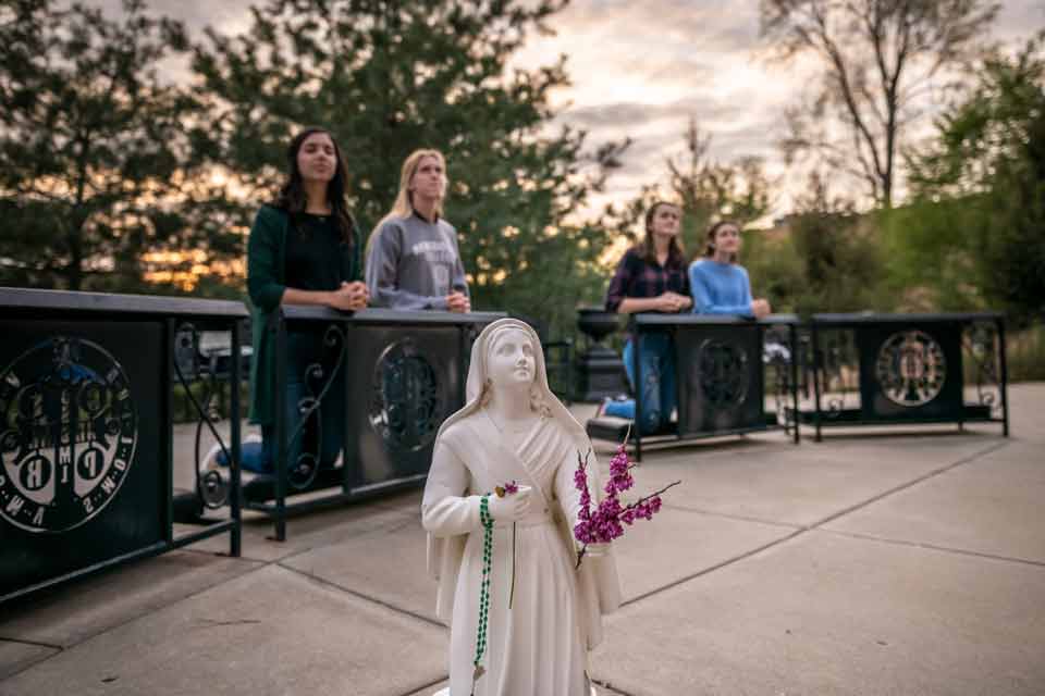 Students pray at Mary's Grotto