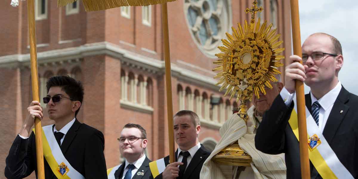 Benedictine College students carry the canopy during a Eucharistic procession