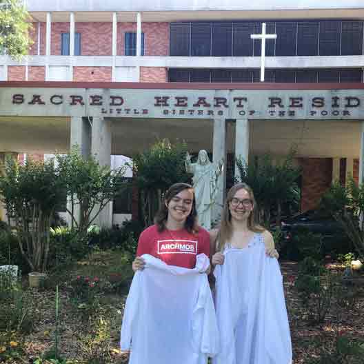 Karol and Anna Arensberg with isolation gowns that the made for the Little Sisters of the Poor