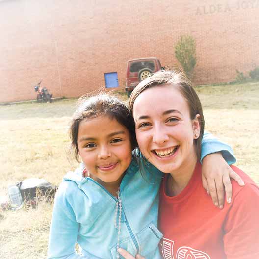A student poses for a photo with a child in Guatemala