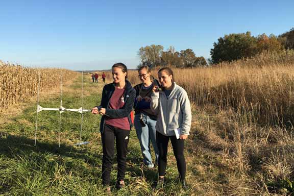 Biology students use a research instrument in a field