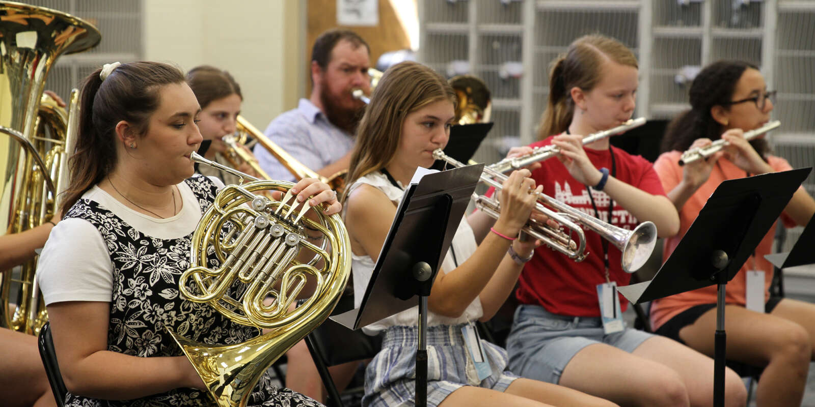 Students performing using brass and woodwind instruments