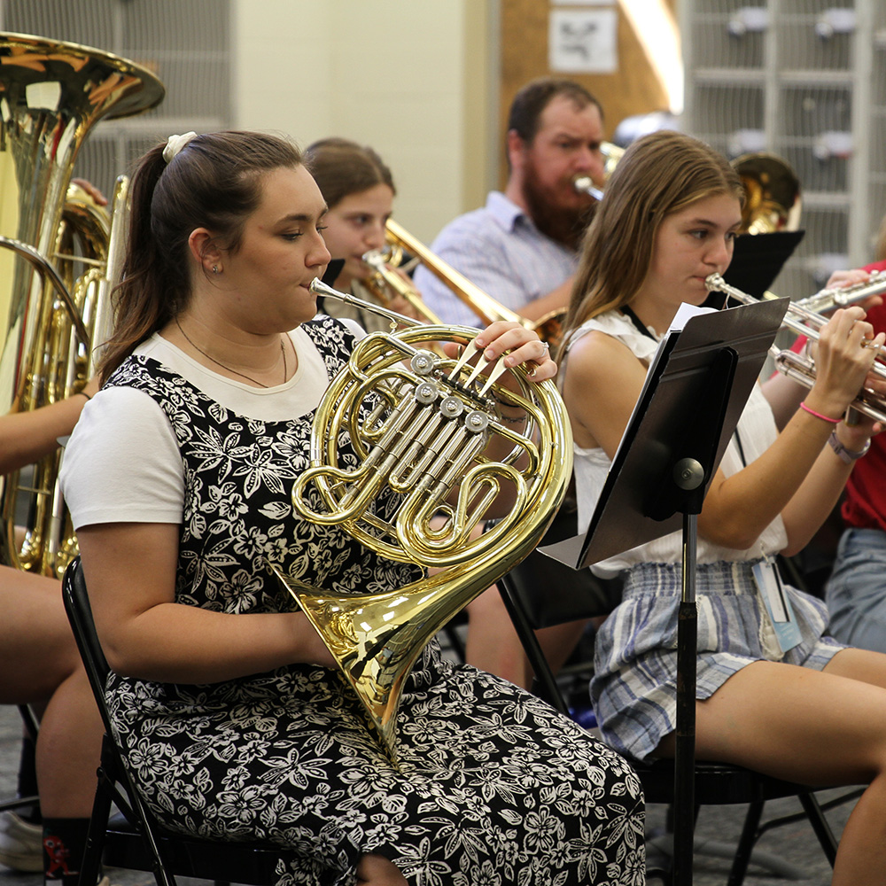 Students performing using brass and woodwind instruments