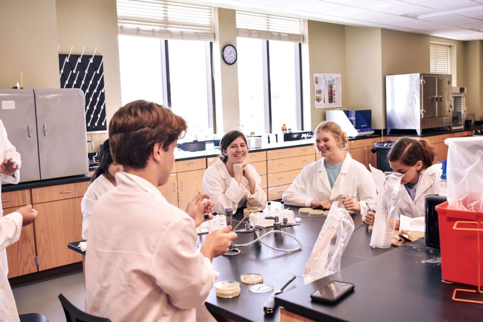 Students in lab coats with petri dishes