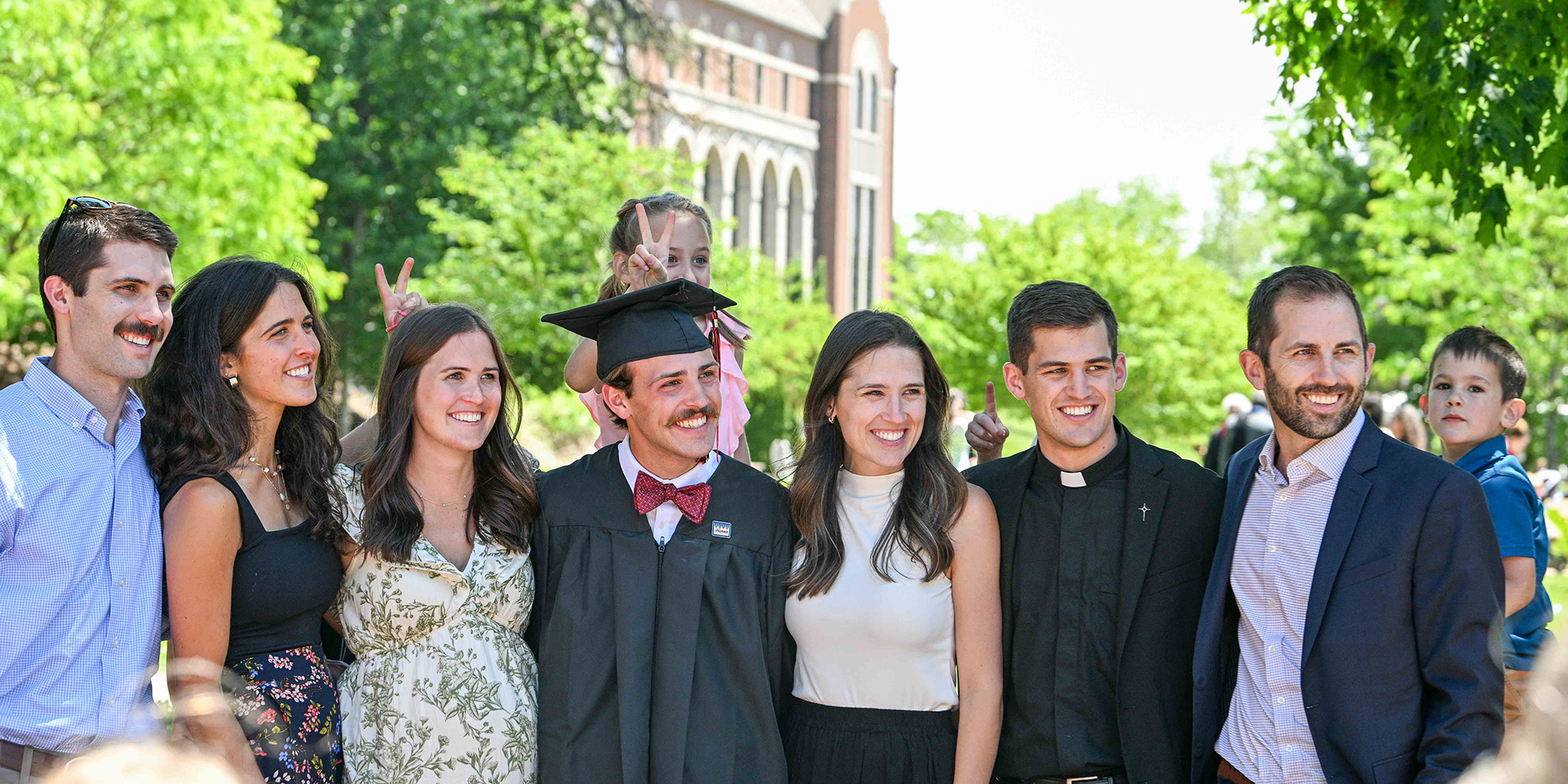 A graduate poses for a photo with family after Commencement