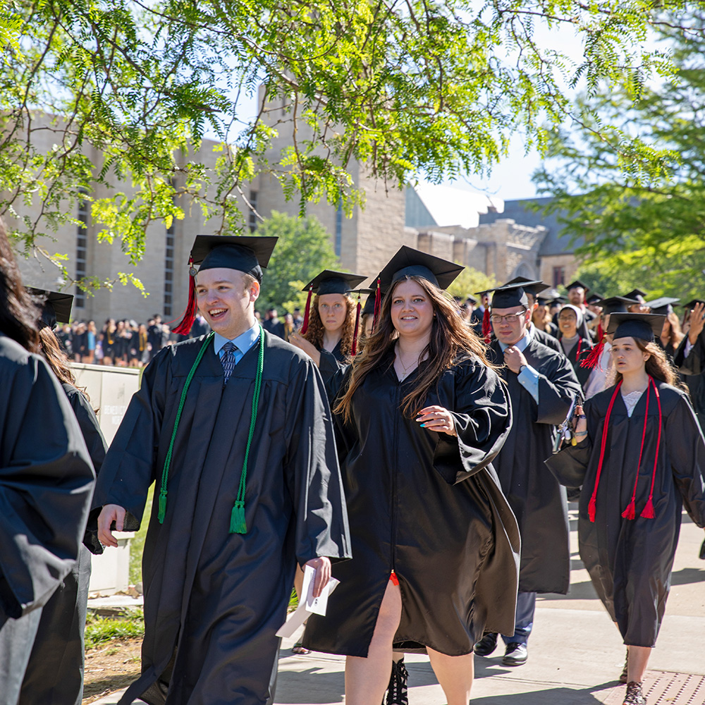 Graduates process across campus to the Commencement ceremony