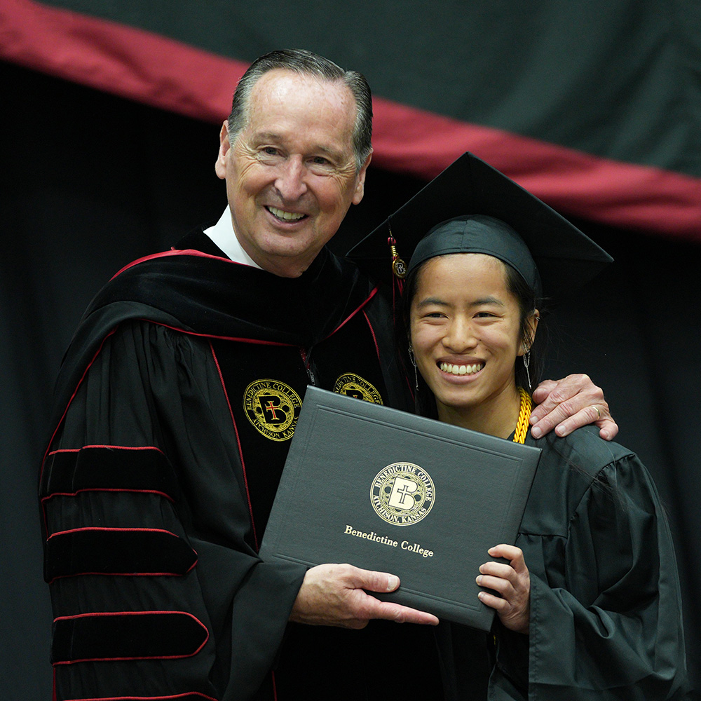 A graduate poses with President Minnis during the Commencement ceremony