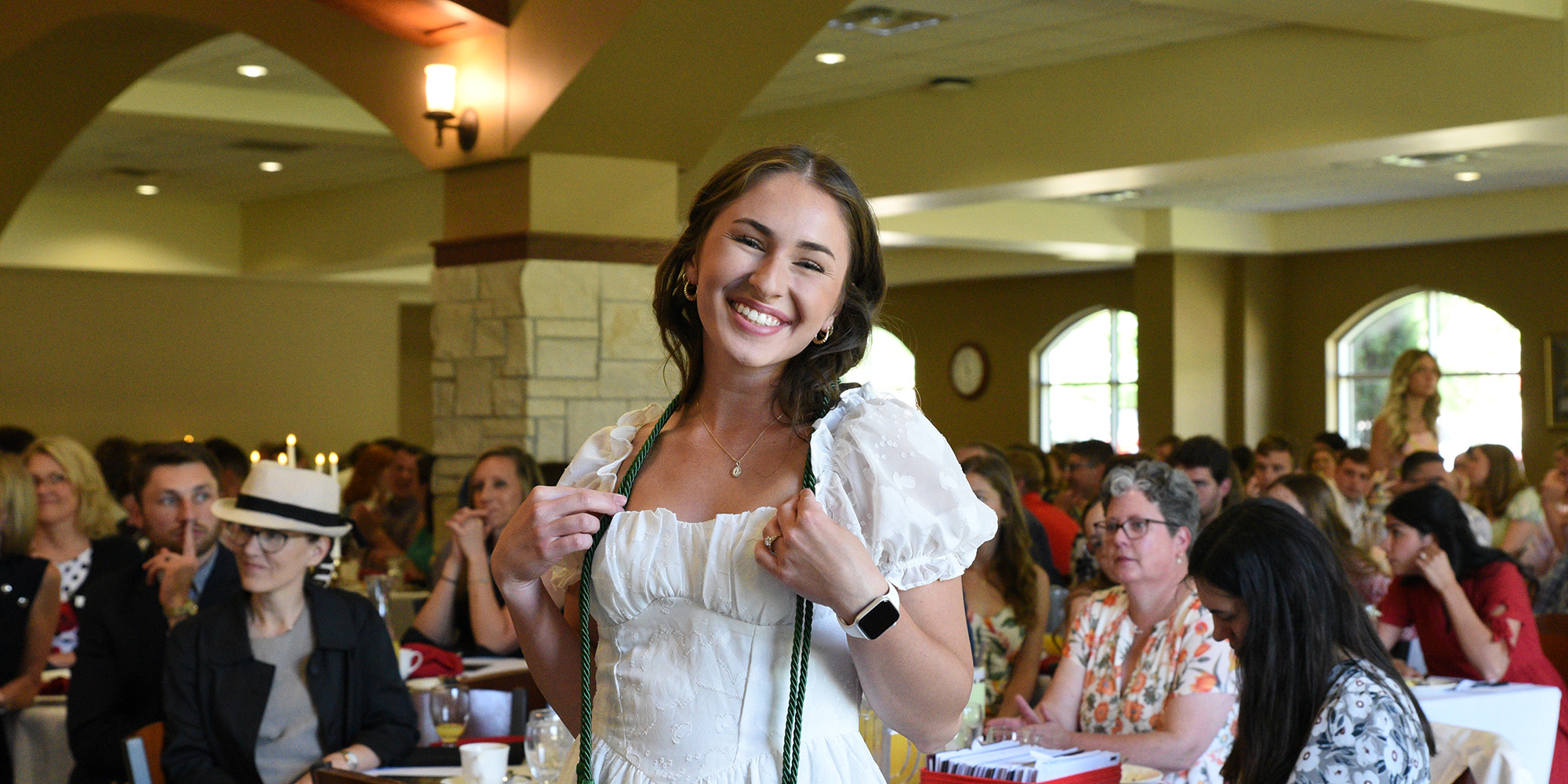 A graduate with her honor cord at the Champagne Brunch
