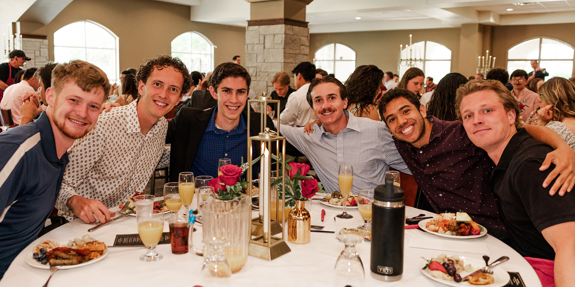 Graduates around a table at the Senior Champagne Brunch