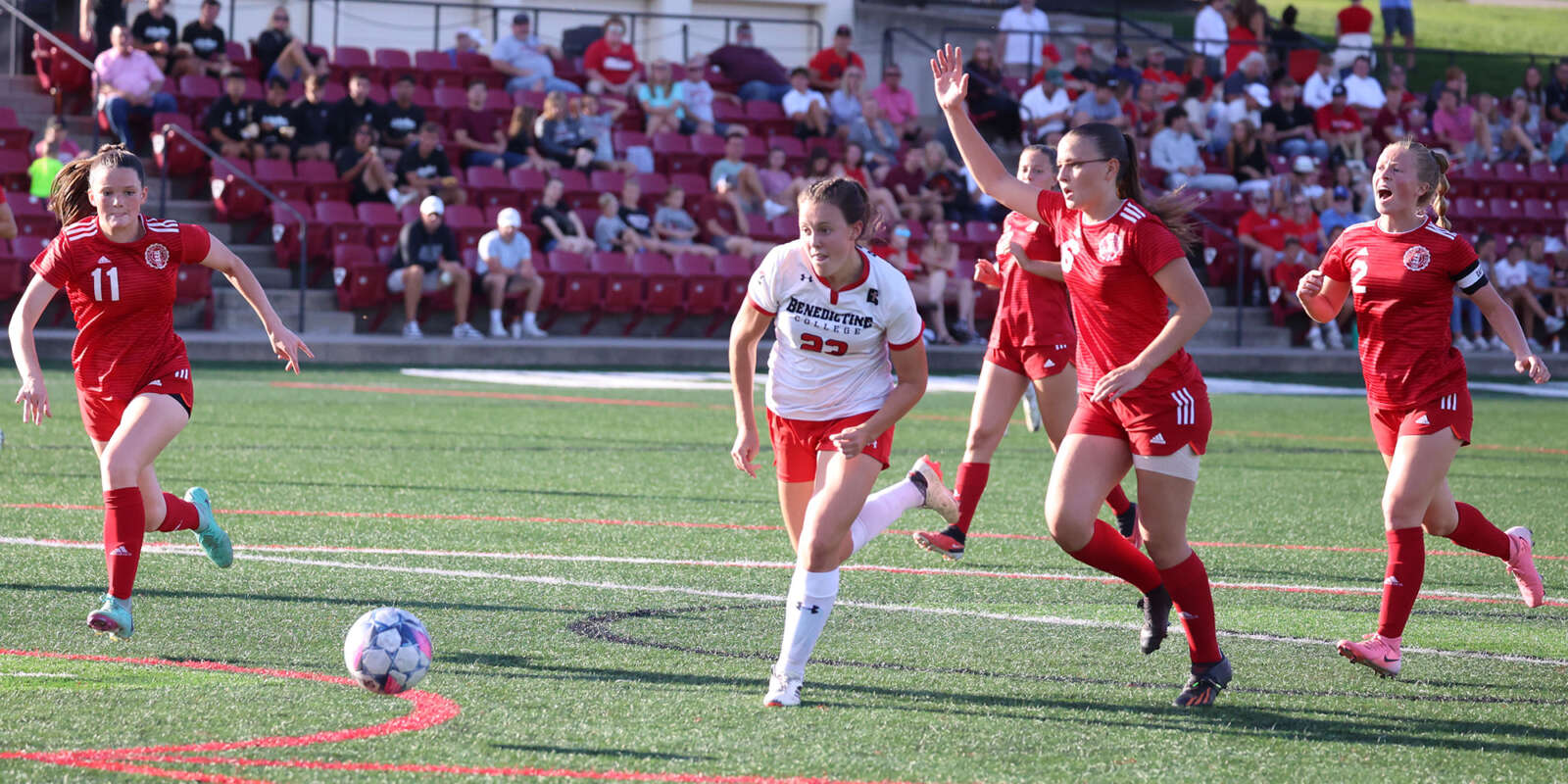 Players chase the ball during a Women's Soccer game