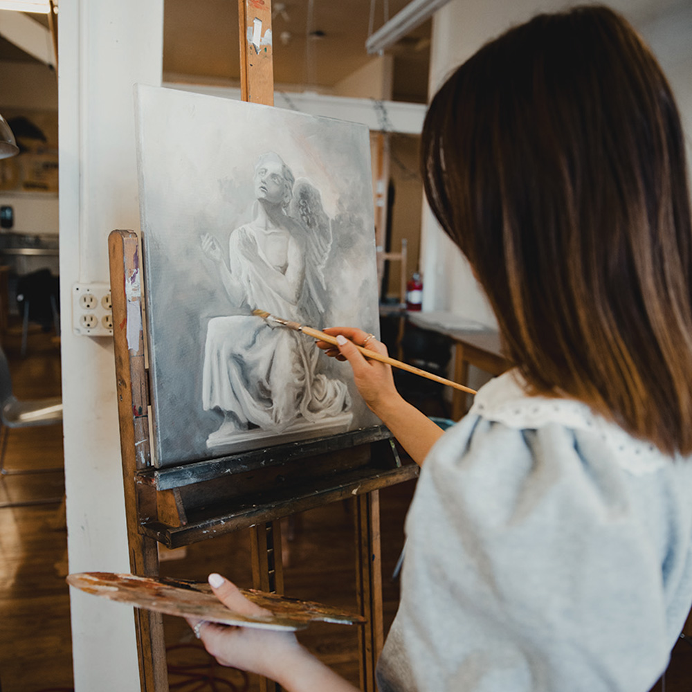 A student painting in a studio