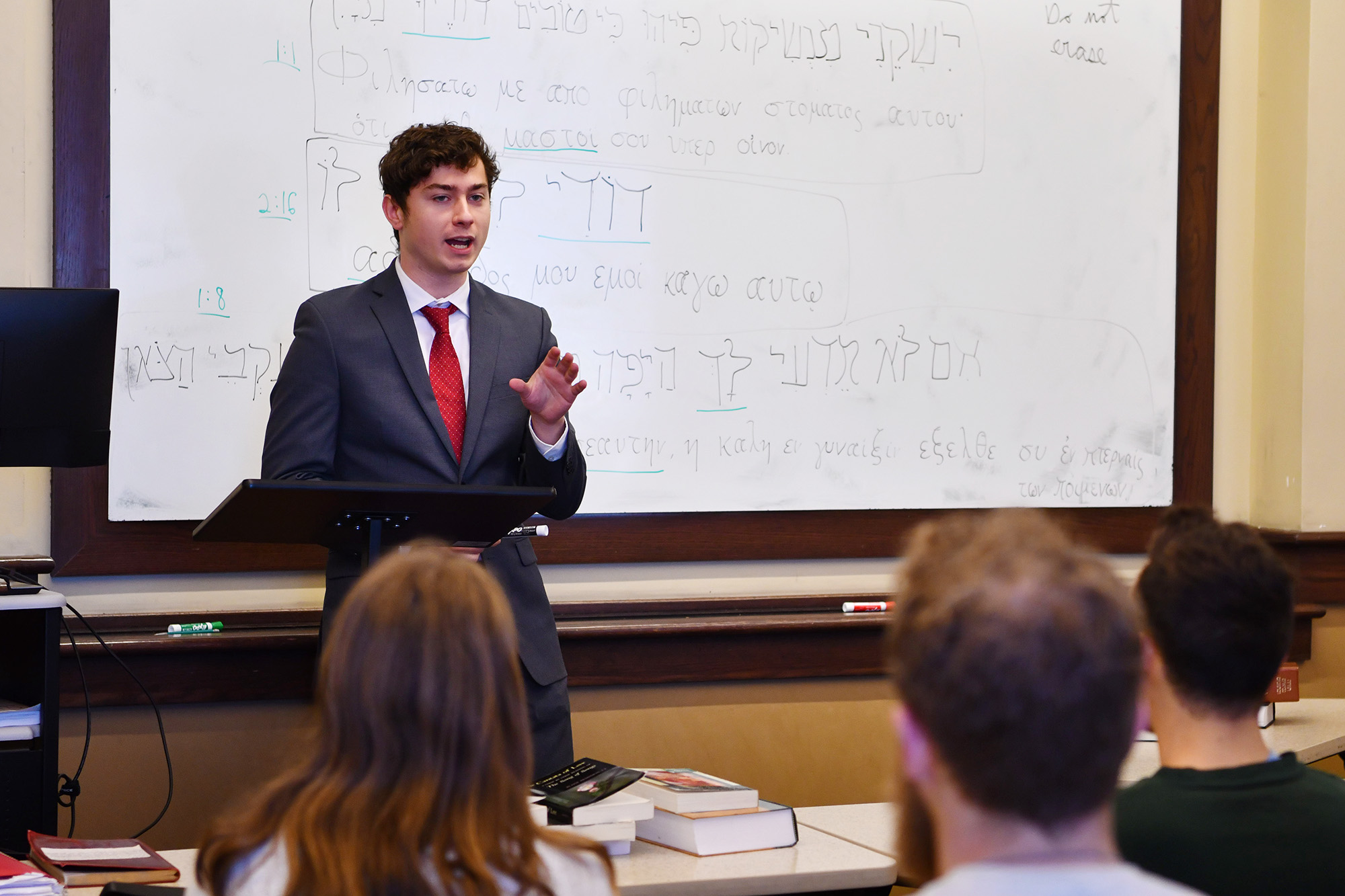 A student gives a presentation to a group in a classroom