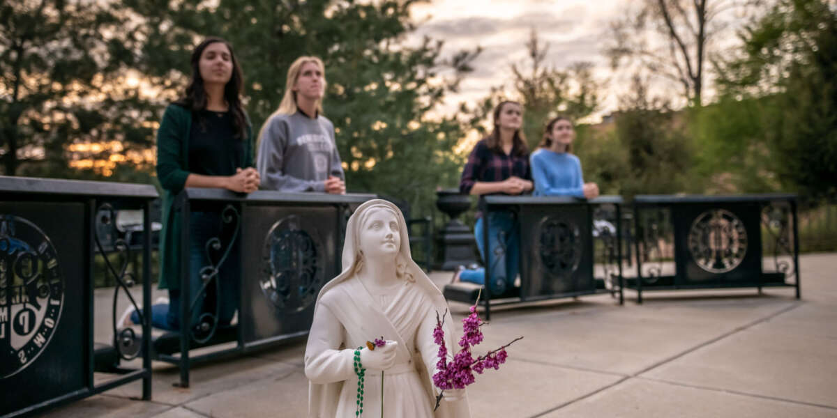 Students pray in Mary's Grotto