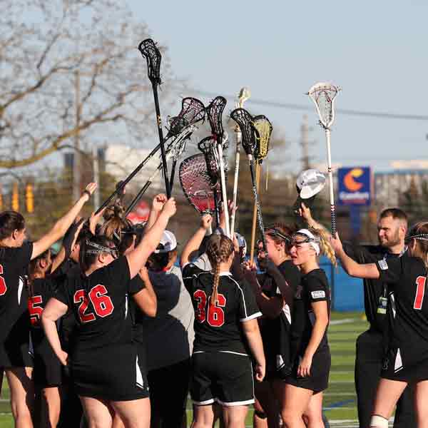 The Women's Lacrosse players raise their sticks together before the 2022 NAIA Championship game