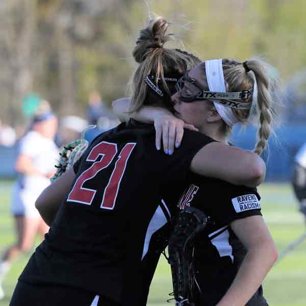 Two Benedictine College Women's Lacrosse players hug during the 2022 NAIA Women's Lacrosse Championship game