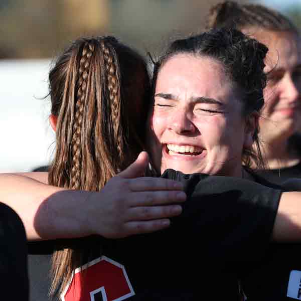 Two Benedictine College Women's Lacrosse players hug after the 2022 NAIA Women's Lacrosse Championship win